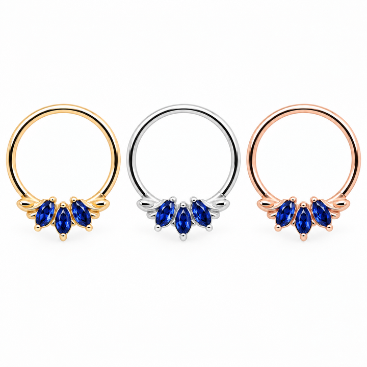 AuAdore Grandeur Lab Blue Sapphire rings in yellow gold, white gold and rose gold from left to right, each with three blue marquise gemstones and smooth hoop tops on white.