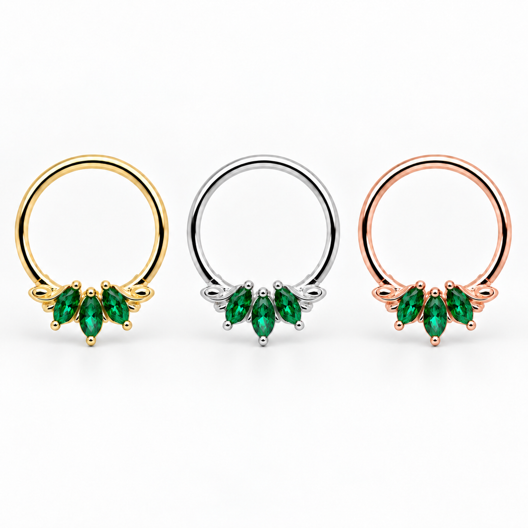 AuAdore Grandeur Lab Emerald rings in yellow gold, white gold and rose gold from left to right, each with three green marquise gemstones and smooth hoop tops on white.