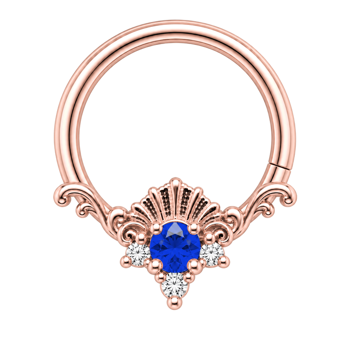 AuAdore Lennox Lab Blue Sapphire and Diamond 16g ring in rose gold, including matching rose-gold prongs and filigree. Blue center, three clear accents and one lower-right seam. Digital color illustration.